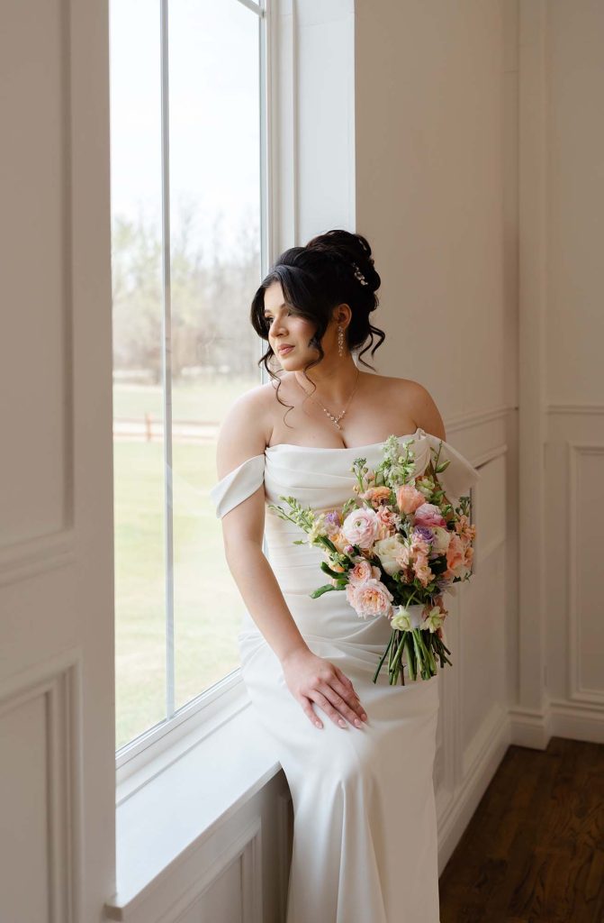 OKC luxury wedding photography, bride looking out window, by Rosie Cheeks Photography.